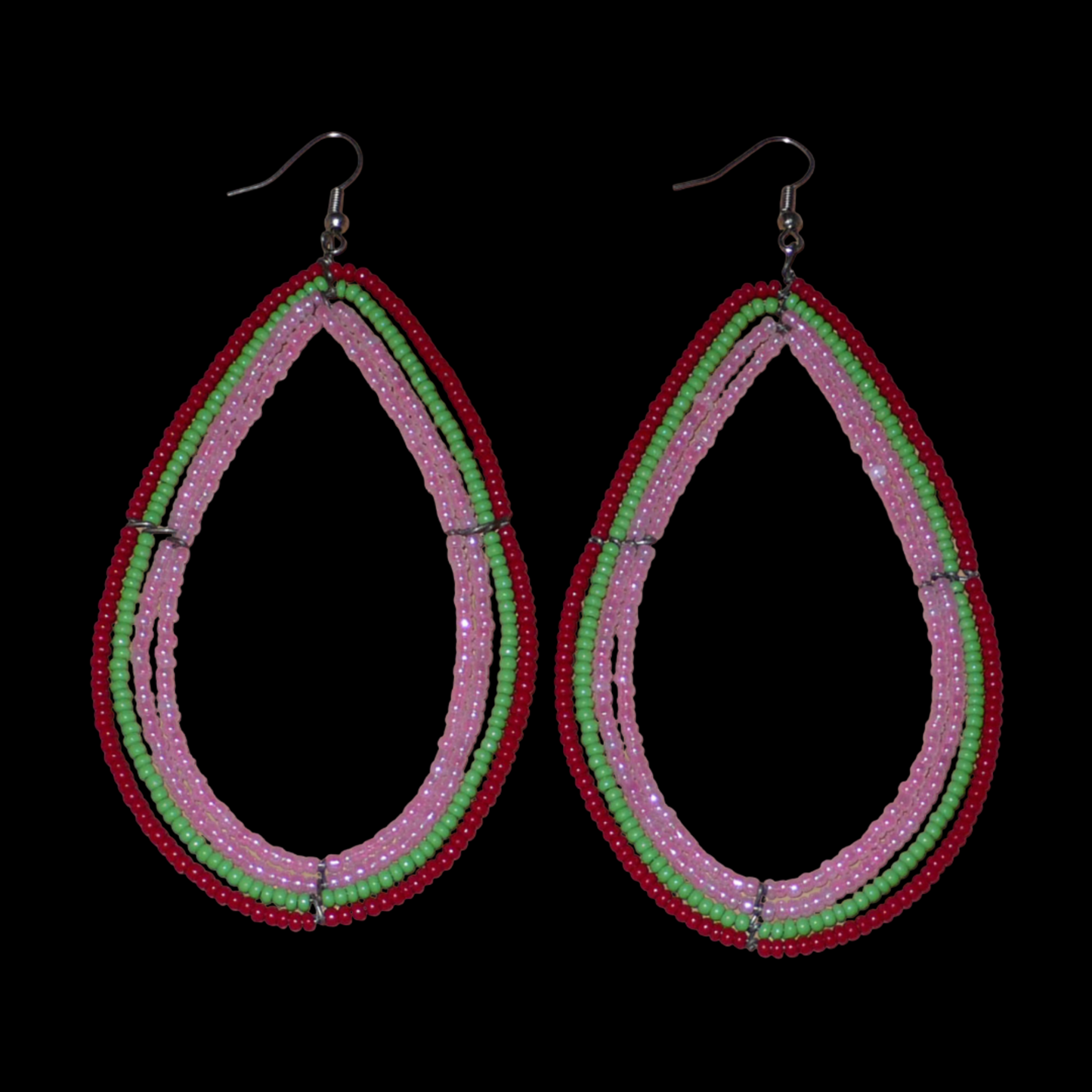 Boucles d'oreilles "oversized" composées de perles de rocaille rose nacré, vertes et rouges enfilées sur quatre rangées de fils de fer montés en forme de gouttes. Surdimensionnées, ces boucles d'oreilles mesurent 11 cm de long et 5,5 cm de large ; elles se portent avec des crochets en acier inoxydable sur des oreilles percées.