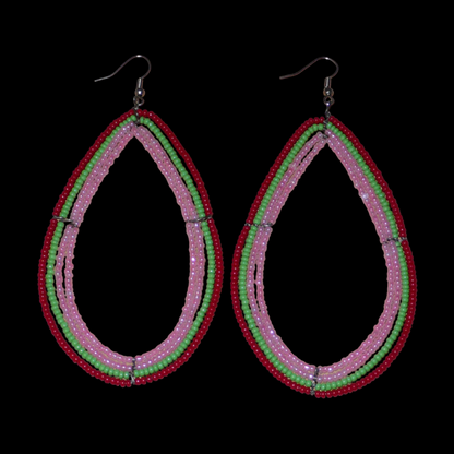 Boucles d'oreilles "oversized" composées de perles de rocaille rose nacré, vertes et rouges enfilées sur quatre rangées de fils de fer montés en forme de gouttes. Surdimensionnées, ces boucles d'oreilles mesurent 11 cm de long et 5,5 cm de large ; elles se portent avec des crochets en acier inoxydable sur des oreilles percées.