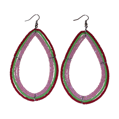 Boucles d'oreilles "oversized" composées de perles de rocaille rose nacré, vertes et rouges enfilées sur quatre rangées de fils de fer montés en forme de gouttes. Surdimensionnées, ces boucles d'oreilles mesurent 11 cm de long et 5,5 cm de large ; elles se portent avec des crochets en acier inoxydable sur des oreilles percées.