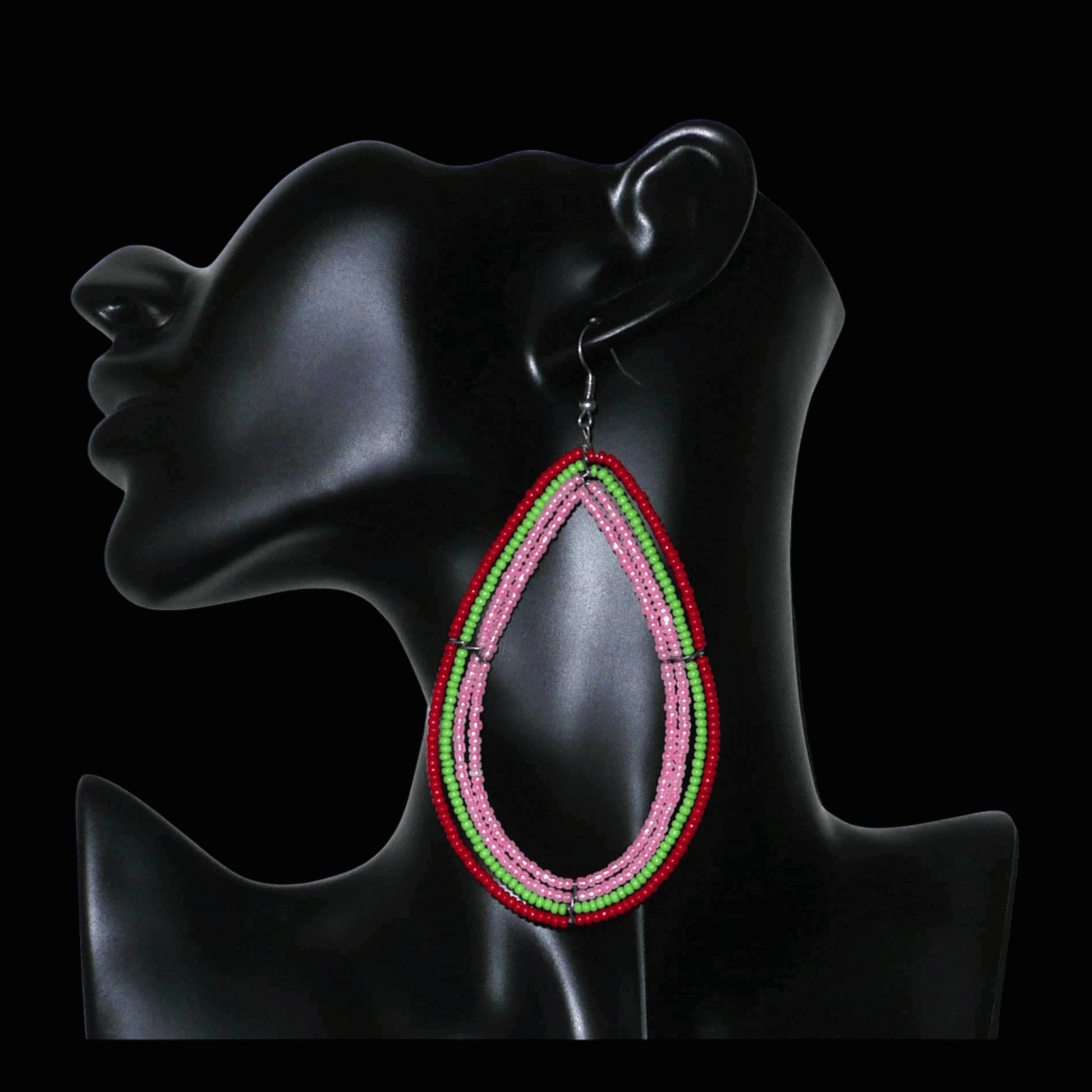Boucles d'oreilles "oversized" composées de perles de rocaille rose nacré, vertes et rouges enfilées sur quatre rangées de fils de fer montés en forme de gouttes. Surdimensionnées, ces boucles d'oreilles mesurent 11 cm de long et 5,5 cm de large ; elles se portent avec des crochets en acier inoxydable sur des oreilles percées.