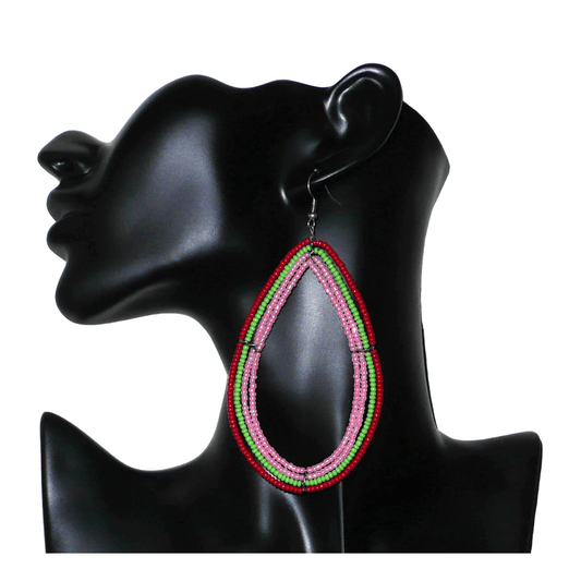 Boucles d'oreilles "oversized" composées de perles de rocaille rose nacré, vertes et rouges enfilées sur quatre rangées de fils de fer montés en forme de gouttes. Surdimensionnées, ces boucles d'oreilles mesurent 11 cm de long et 5,5 cm de large ; elles se portent avec des crochets en acier inoxydable sur des oreilles percées.