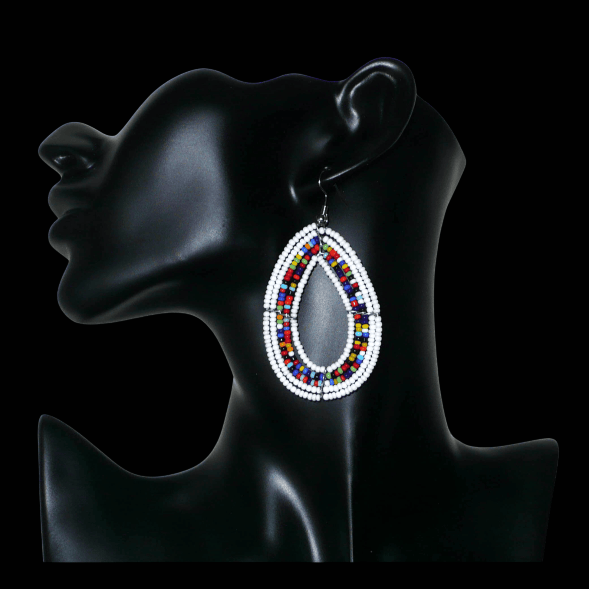 Boucles d'oreilles bohème blanches et multicolores en forme de gouttes faites de perles de rocaille. Elles mesurent 7,5 cm de long et 4 cm de large et se portent sur des oreilles percées.
