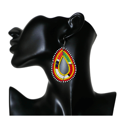 Boucles d'oreilles africaines traditionnelles jaunes et multicolores à motifs ethniques Massai, composées de perles de rocaille montées en forme de gouttes. Elles mesurent 7.5 cm de long et 4.5 cm de large, et se portent sur des oreilles percées.