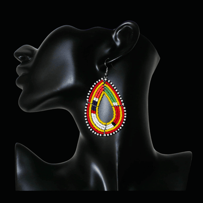 Boucles d'oreilles africaines traditionnelles jaunes et multicolores à motifs ethniques Massai, composées de perles de rocaille montées en forme de gouttes. Elles mesurent 7.5 cm de long et 4.5 cm de large, et se portent sur des oreilles percées.