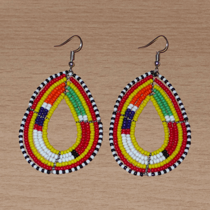 Boucles d'oreilles africaines traditionnelles jaunes et multicolores à motifs ethniques Massai, composées de perles de rocaille montées en forme de gouttes. Elles mesurent 7.5 cm de long et 4.5 cm de large, et se portent sur des oreilles percées.