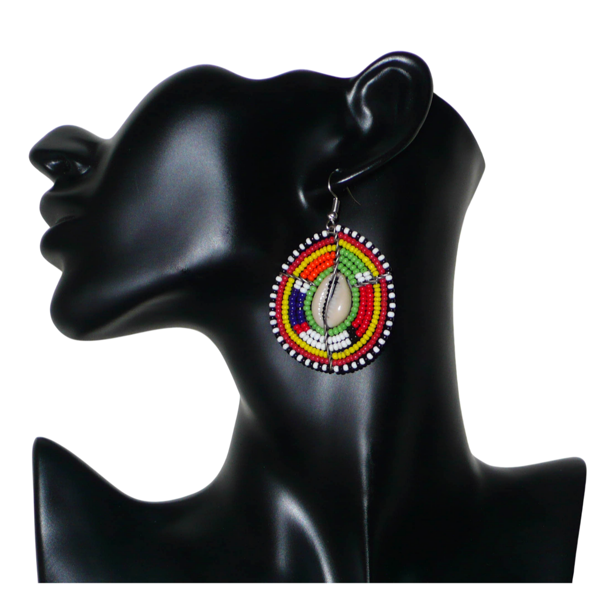 Boucles d'oreilles africaines ethniques aux motifs tribaux traditionnels caractéristiques de l'artisanat Massai. Confectionnées au Kenya, elles sont composées de perles de rocaille vertes et multicolores et de coquillages cauris fixés sur des fils de fer montés en forme de boucliers Massai. De taille moyenne, elles mesurent 6 cm de long et 4 cm de large, et se portent avec des crochets en acier inoxydable sur des oreilles percées.