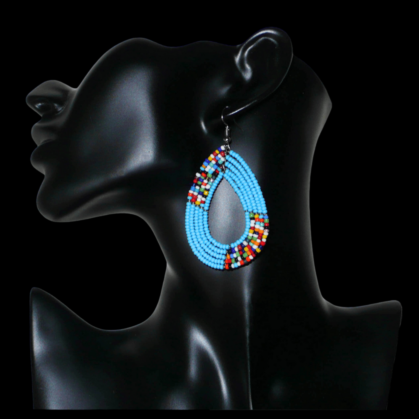 Boucles d'oreilles kenyanes multi-rangs en perles de rocaille bleu ciel et multicolores. Elles mesurent 7 cm de long et 4 cm de large et se portent sur des oreilles percées.