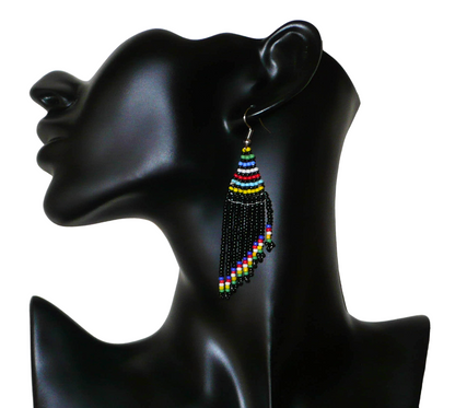 Boucles d'oreilles ethniques à franges composées de perles noires et multicolores. Elles mesure 8,5 cm de long et 2 cm de large, et se portent avec des crochets en acier inoxydables sur des oreilles percées.