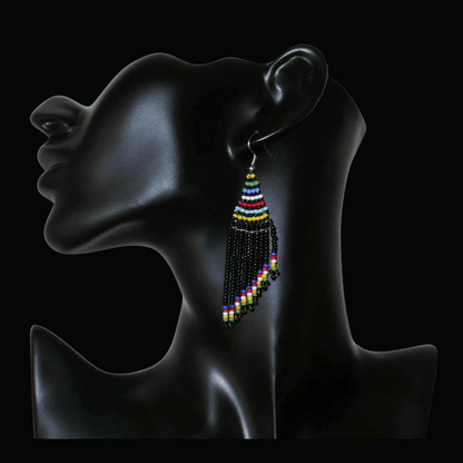 Boucles d'oreilles ethniques sud-africaines à franges asymétriques composées d'un tissage de perles de rocaille noires et multicolores. Elles mesurent 8.5 cm de long et 2 cm de large.