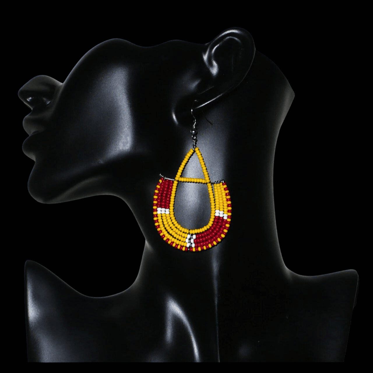 Boucles d'oreilles ethniques tricolores en forme d'ancres composées de perles de rocaille jaunes, rouges et blanches ; elles mesurent 7,5 cm de long et 4 cm de large et se portent avec des crochets en acier inoxydable sur.des oreilles percées.