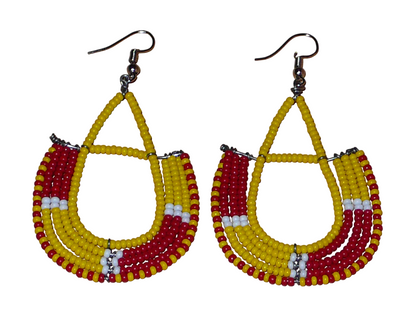 Boucles d'oreilles ethniques tricolores en forme d'ancres composées de perles de rocaille jaunes, rouges et blanches ; elles mesurent 7,5 cm de long et 4 cm de large et se portent avec des crochets en acier inoxydable sur.des oreilles percées.