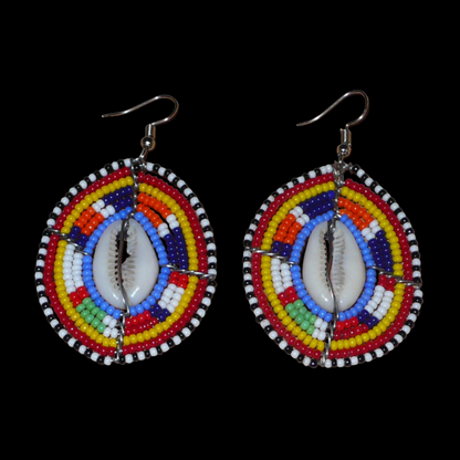 Boucles d'oreilles africaines en forme de boucliers Massai composées de perles multicolores et de coquillages cauris. Ces boucles d'oreilles aux accents ethniques afro chic mesurent 7 cm de long et 4 cm de large et se portent avec des crochets en acier inoxydable sur des oreilles percées. 