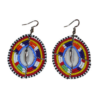 Boucles d'oreilles africaines en forme de boucliers Massai composées de perles multicolores et de coquillages cauris. Ces boucles d'oreilles aux accents ethniques afro chic mesurent 7 cm de long et 4 cm de large et se portent avec des crochets en acier inoxydable sur des oreilles percées. 