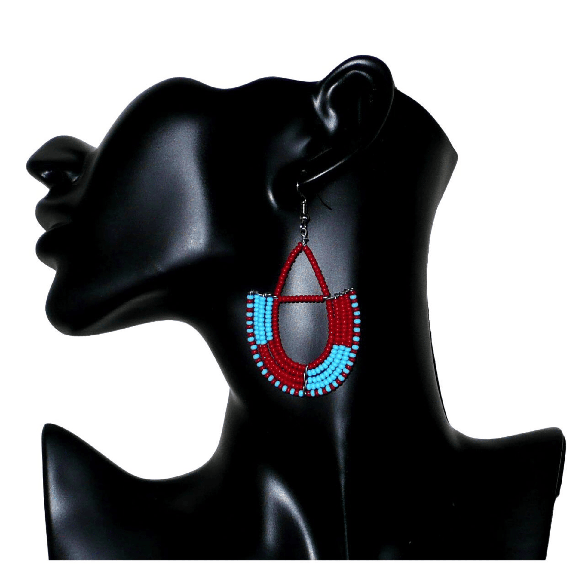 Boucles d'oreilles africaines Massai rouges et bleues composées de perles de rocaille glissées sur des structures géométriques en fils de fer montées en forme d'ancres. Ces boucles d'oreilles bicolores mesurent 7,5 cm de long et 4 cm de large et se portent avec des crochets en acier inoxydable.