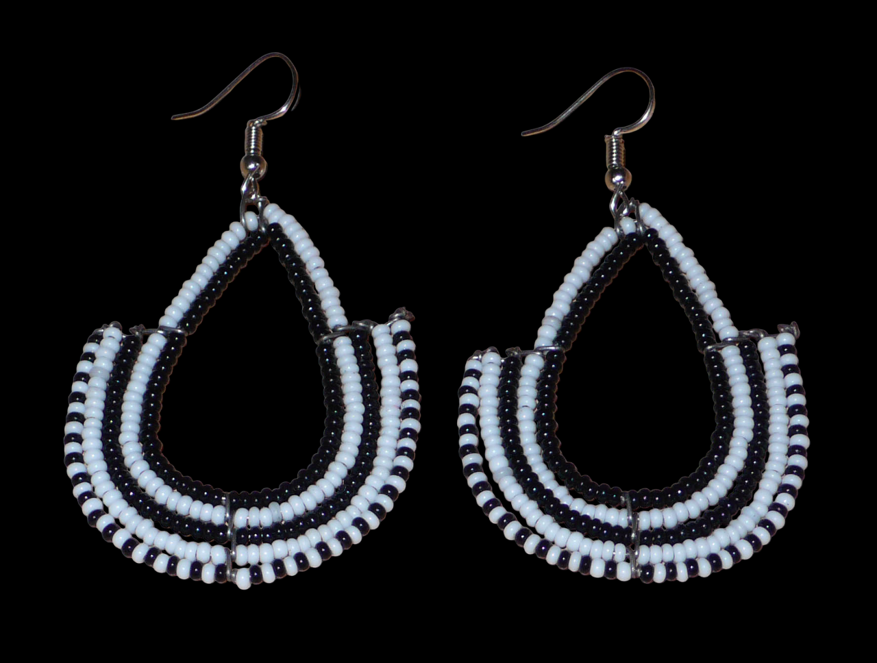 Boucles d'oreilles ethniques bicolores de conception artisanale kenyane : elles se composent de perles de rocaille noires et blanches montées en forme d'ancres. De taille moyenne, cette paire de boucles d'oreilles aux accents ethniques chic mesure 7 cm de long et 4 cm de large, et se porte avec des crochets en acier inoxydable sur des oreilles percées.