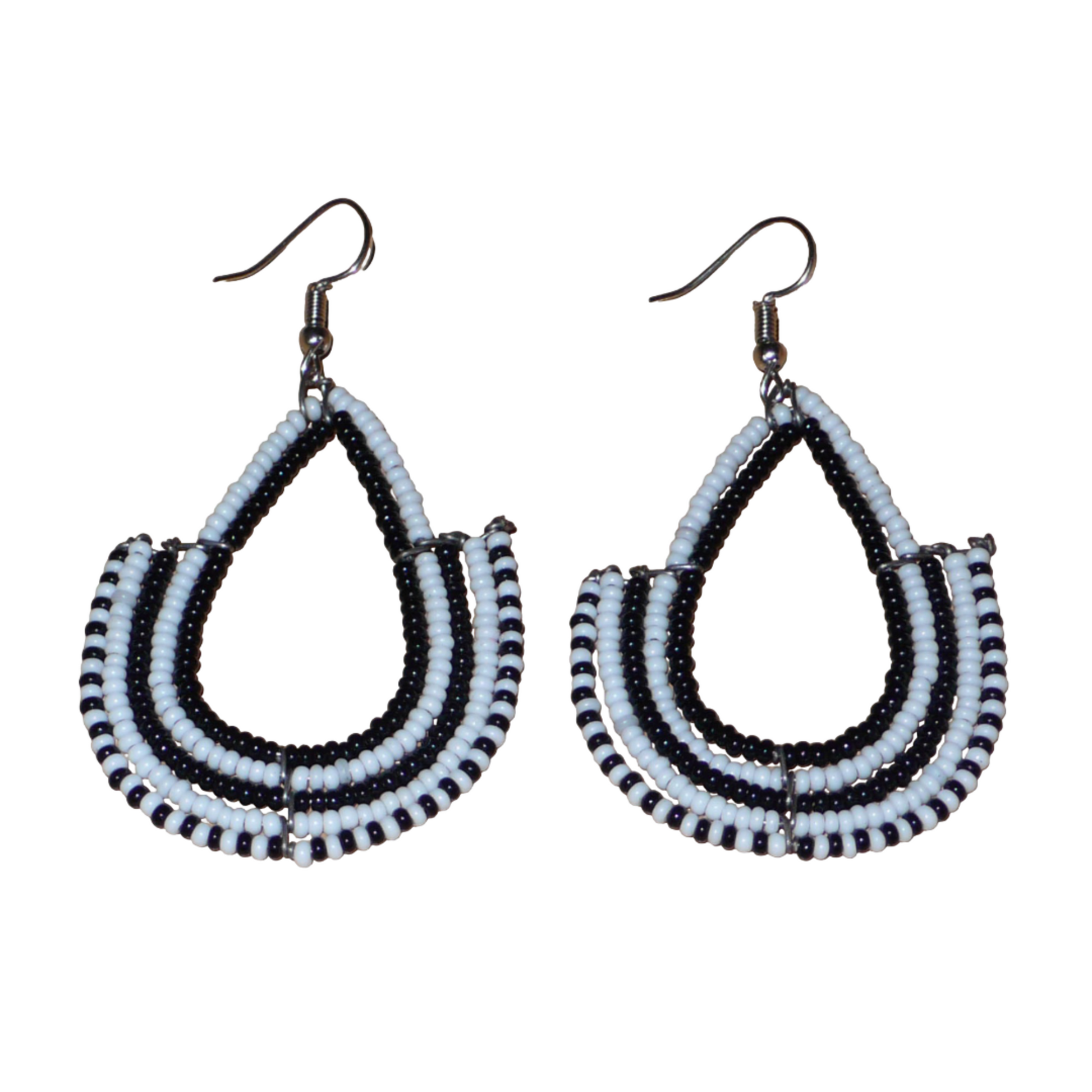 Boucles d'oreilles ethniques bicolores de conception artisanale kenyane : elles se composent de perles de rocaille noires et blanches montées en forme d'ancres. De taille moyenne, cette paire de boucles d'oreilles aux accents ethniques chic mesure 7 cm de long et 4 cm de large, et se porte avec des crochets en acier inoxydable sur des oreilles percées.