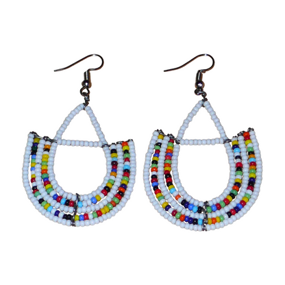 Boucles d'oreilles ethniques blanches et multicolores composées de perles de rocaille montées en forme d'ancres. Ces boucles d'oreilles mesurent 7 cm de long et 4 cm de large ; elles se portent avec des crochets en acier inoxydable sur des oreilles percées.