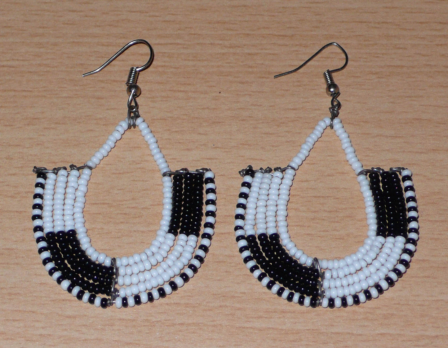 Boucles d'oreilles kenyanes au style ethnique chic composées de perles de rocaille blanches et multicolores. Elles mesurent 7 cm de long et 4 cm de large et se portent sur des oreilles percées.