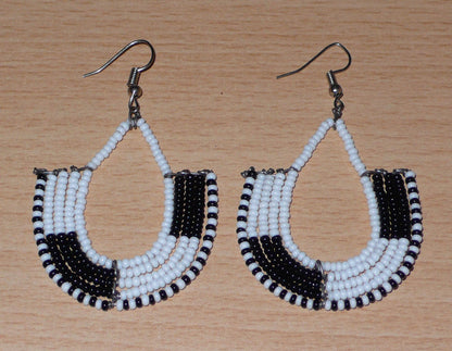 Boucles d'oreilles kenyanes au style ethnique chic composées de perles de rocaille blanches et multicolores. Elles mesurent 7 cm de long et 4 cm de large et se portent sur des oreilles percées.