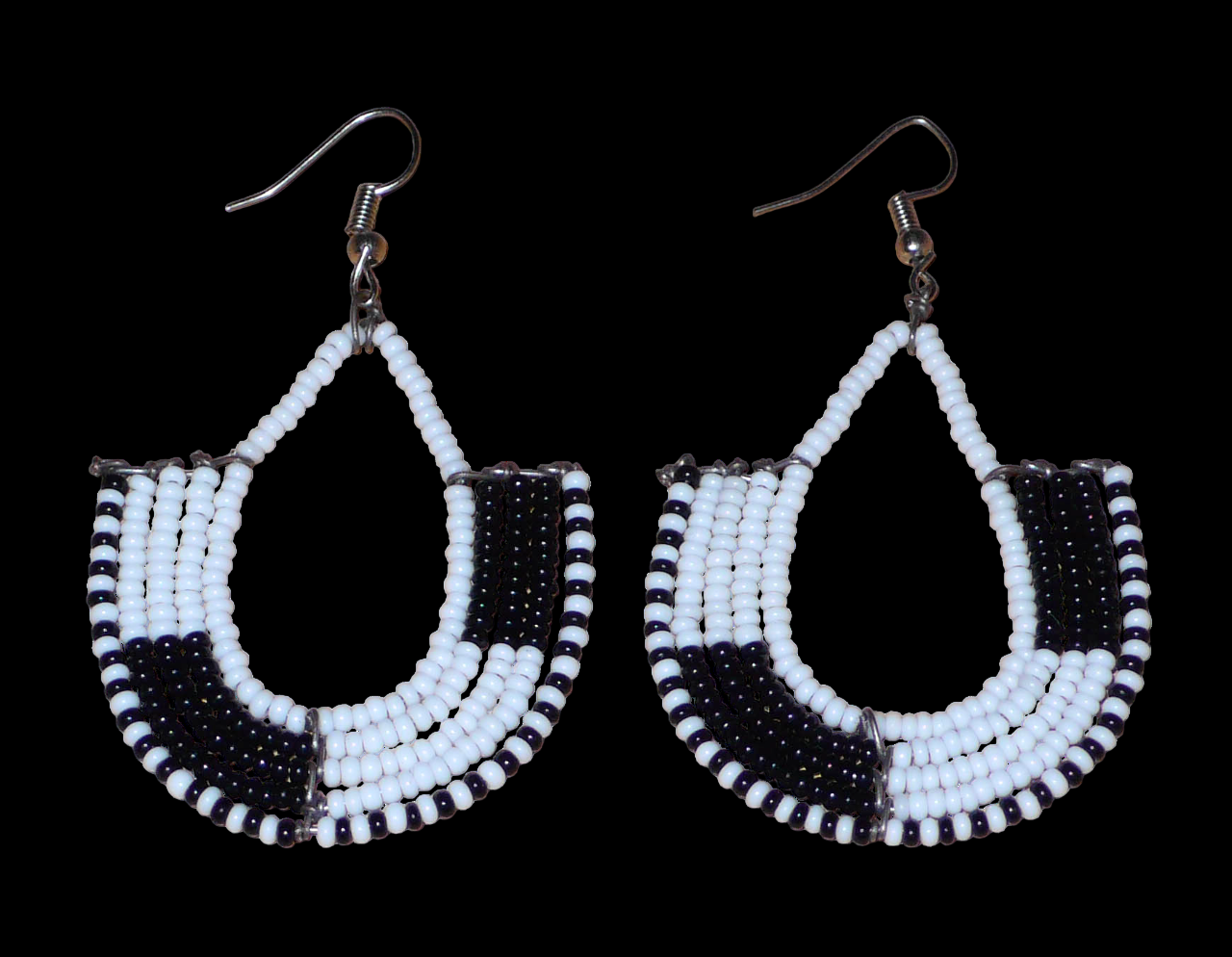 Boucles d'oreilles kenyanes au style ethnique chic composées de perles de rocaille blanches et multicolores. Elles mesurent 7 cm de long et 4 cm de large et se portent sur des oreilles percées.