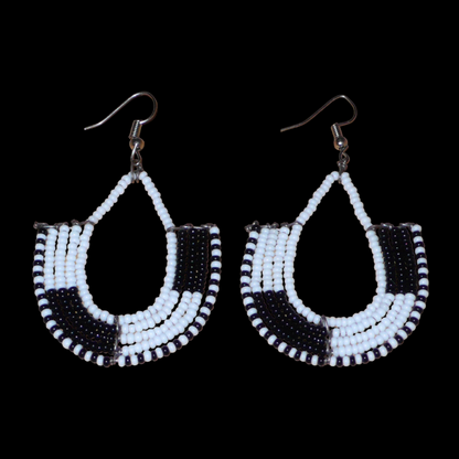 Boucles d'oreilles kenyanes au style ethnique chic composées de perles de rocaille blanches et multicolores. Elles mesurent 7 cm de long et 4 cm de large et se portent sur des oreilles percées.