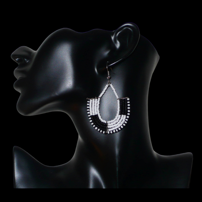 Boucles d'oreilles kenyanes au style ethnique chic composées de perles de rocaille blanches et multicolores. Elles mesurent 7 cm de long et 4 cm de large et se portent sur des oreilles percées.