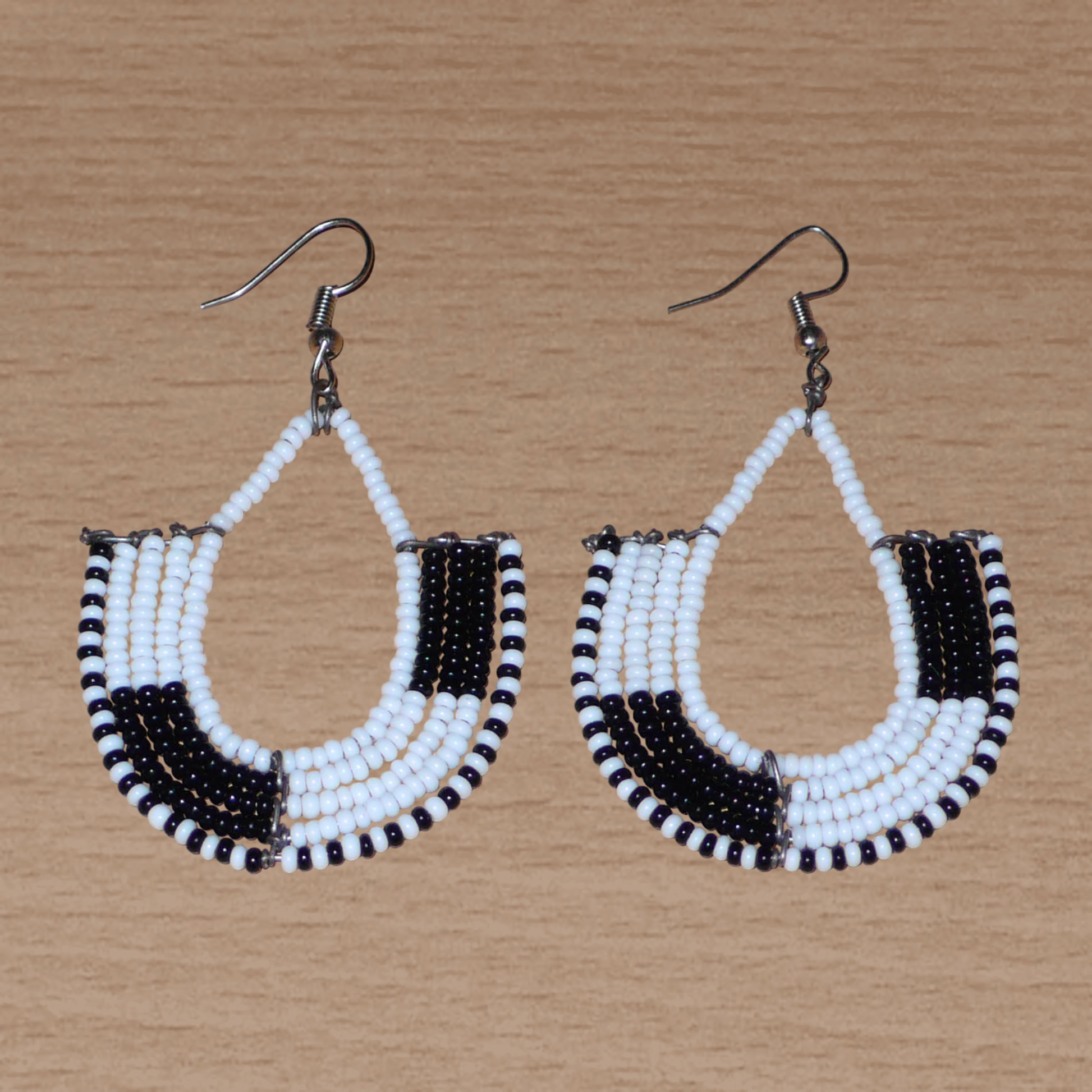 Boucles d'oreilles kenyanes au style ethnique chic composées de perles de rocaille blanches et multicolores. Elles mesurent 7 cm de long et 4 cm de large et se portent sur des oreilles percées.