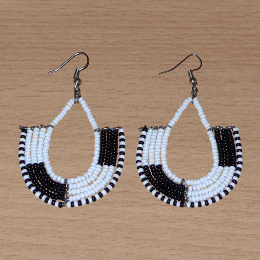 Boucles d'oreilles kenyanes au style ethnique chic composées de perles de rocaille blanches et multicolores. Elles mesurent 7 cm de long et 4 cm de large et se portent sur des oreilles percées.