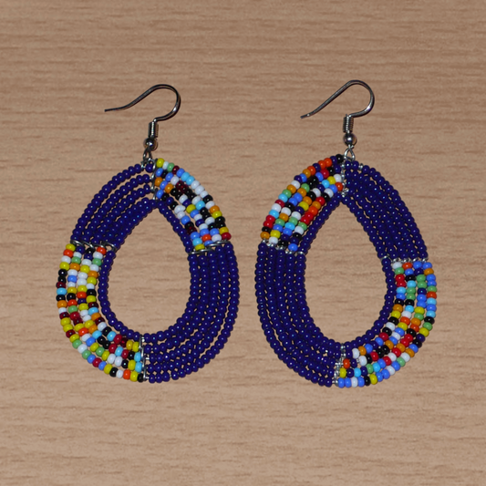 Boucles d'oreilles kenyanes multi-rangs en forme de gouttes faites de perles de rocaille bleu foncé et multicolores. Elles mesurent 7 cm de long et 4.5 cm de large, et se portent sur des oreilles percées.