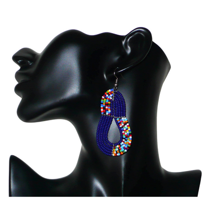 Boucles d'oreilles ethniques bleu marine et multicolores : de fabrication artisanale kenyane Massai, elles se composent de perles de rocaille glissées sur plusieurs rangées de fils de fer. Ces boucles d'oreilles aux accents afro bohème mesurent 8 cm de long et 3.5 cm de large, et se portent avec des crochets en acier inoxydable sur des oreilles percées.