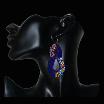 Boucles d'oreilles ethniques bleu marine et multicolores : de fabrication artisanale kenyane Massai, elles se composent de perles de rocaille glissées sur plusieurs rangées de fils de fer. Ces boucles d'oreilles aux accents afro bohème mesurent 8 cm de long et 3.5 cm de large, et se portent avec des crochets en acier inoxydable sur des oreilles percées.