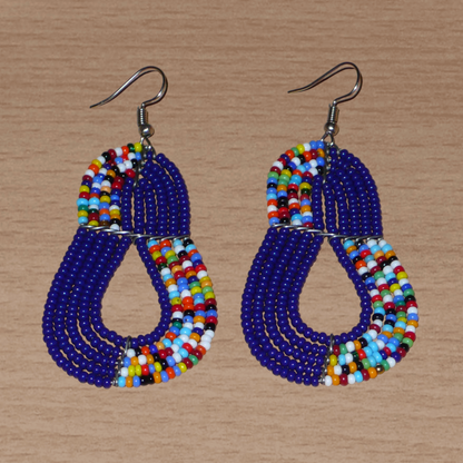 Boucles d'oreilles ethniques bleu marine et multicolores : de fabrication artisanale kenyane Massai, elles se composent de perles de rocaille glissées sur plusieurs rangées de fils de fer. Ces boucles d'oreilles aux accents afro bohème mesurent 8 cm de long et 3.5 cm de large, et se portent avec des crochets en acier inoxydable sur des oreilles percées.