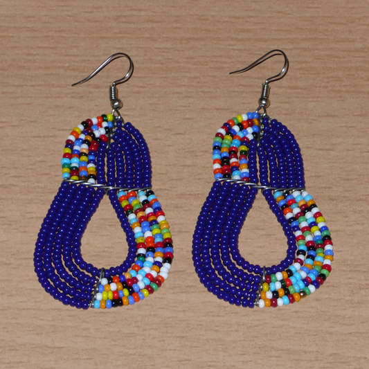 Boucles d'oreilles ethniques bleu marine et multicolores : de fabrication artisanale kenyane Massai, elles se composent de perles de rocaille glissées sur plusieurs rangées de fils de fer. Ces boucles d'oreilles aux accents afro bohème mesurent 8 cm de long et 3.5 cm de large, et se portent avec des crochets en acier inoxydable sur des oreilles percées.