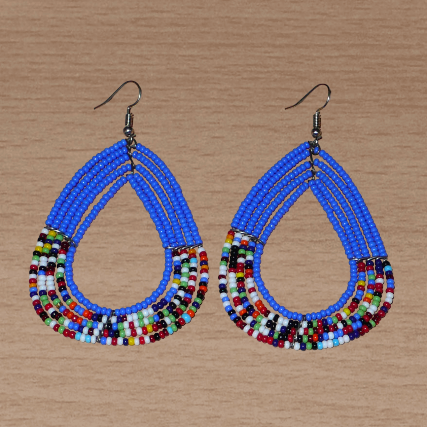 Boucles d'oreilles ethniques multi-rangs bleues et multicolores en perles de rocaille. Elles mesurent 8.5 cm de long et 5 cm de large, et se portent sur des oreilles percées.