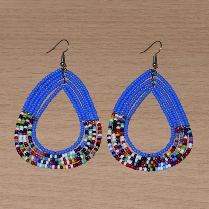 Boucles d'oreilles ethniques multi-rangs bleues et multicolores en perles de rocaille. Elles mesurent 8.5 cm de long et 5 cm de large, et se portent sur des oreilles percées.