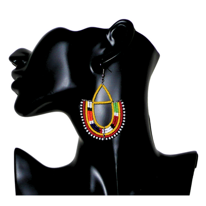 Boucles d'oreilles africaines traditionnelles aux couleurs ethniques et motifs Massai rappelant le style afro chic des années 70 : elles se composent de perles de rocaille jaunes et multicolores fixées sur des structures en fils de fer en forme d'ancres. Elles mesurent 7.5 cm de long et 4.5 cm de large, elles se portent avec des crochets en acier inoxydable sur des oreilles percées.