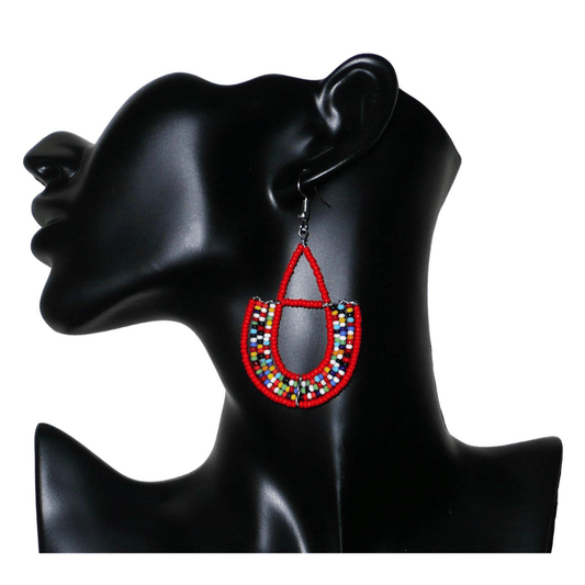 Boucles d'oreilles africaines rouges et multicolores en forme d'ancres. Elles mesurent 7,5 cm de long et 4 cm de large et se portent avec des crochets en acier inoxydable sur des oreilles percées.