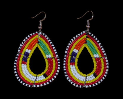 Boucles d'oreilles ethniques de tradition Massai en forme de gouttes faites de perles de rocaille jaunes et multicolores. Elles mesurent 8 cm de long et 4 cm de large et se portent avec des crochets en acier inoxydable sur des oreilles percées. 