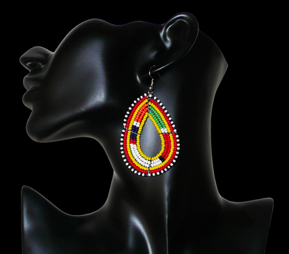 Boucles d'oreilles ethniques de tradition Massai en forme de gouttes faites de perles de rocaille jaunes et multicolores. Elles mesurent 8 cm de long et 4 cm de large et se portent avec des crochets en acier inoxydable sur des oreilles percées. 