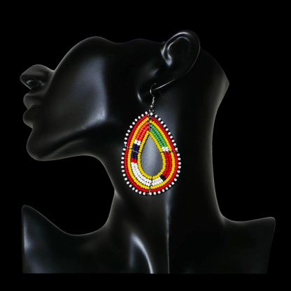 Boucles d'oreilles ethniques de tradition Massai en forme de gouttes faites de perles de rocaille jaunes et multicolores. Elles mesurent 8 cm de long et 4 cm de large et se portent avec des crochets en acier inoxydable sur des oreilles percées. 