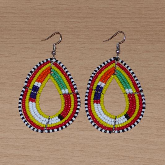 Boucles d'oreilles ethniques de tradition Massai en forme de gouttes faites de perles de rocaille jaunes et multicolores. Elles mesurent 8 cm de long et 4 cm de large et se portent avec des crochets en acier inoxydable sur des oreilles percées. 