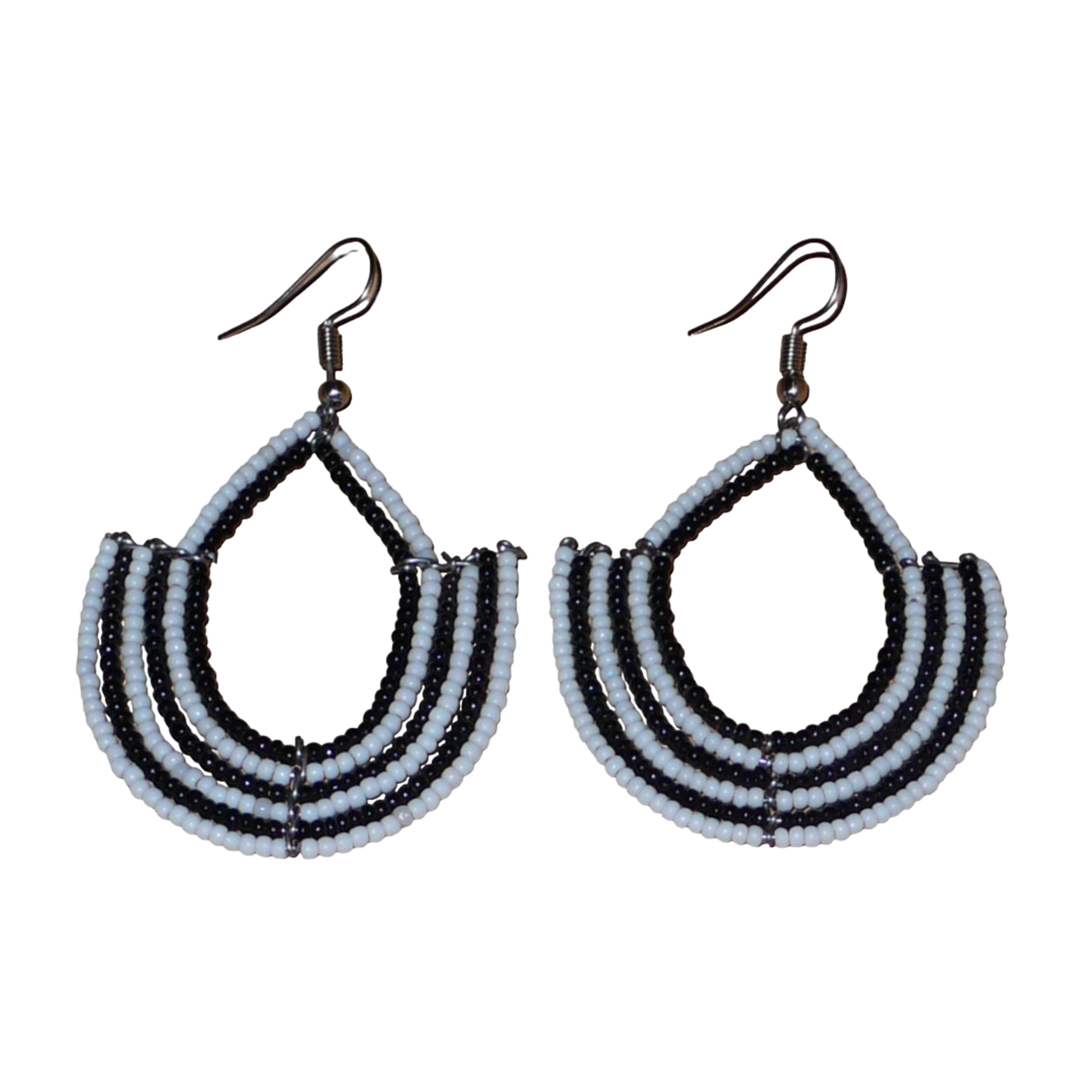 Boucles d'oreilles bicolores afro chic noires et blanches en forme d'ancres composées de perles de rocaille. De taille moyenne, elles mesurent 7 cm de long et 4 cm de large et se portent avec des crochets en acier inoxydable sur des oreilles percées.