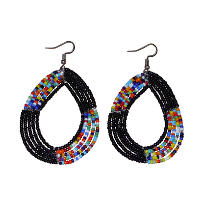 Longues boucles d'oreilles multi-rangs noires et multicolores en forme de gouttes composées de perles de rocaille. Elles mesurent 8 cm de long sur 5 cm de large ; et se portent avec des crochets sur des oreilles percées.