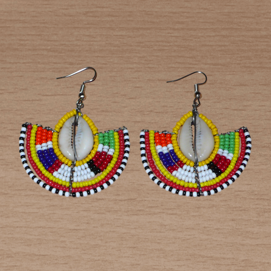 Ces jolies boucles d'oreilles à l'allure ethnique afro chic se composent de perles de rocaille jaunes et multicolores et de coquillages cauris. De taille moyenne, elles mesurent 6 cm de long et 4.5 cm de large, et se portent avec des crochets en acier inoxydable sur des oreilles percées.