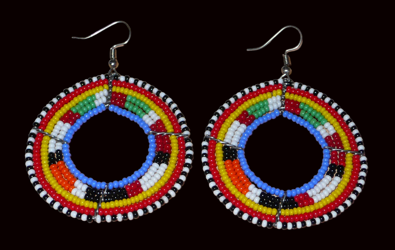 Boucles d'oreilles africaines rondes traditionnelles à motifs ethniques Massai composées de perles de rocaille bleues et multicolores. Ces créoles perlées mesurent 7 cm de long et 5 cm de large ; elles se portent avec des crochets en acier inoxydable sur des oreilles percées.