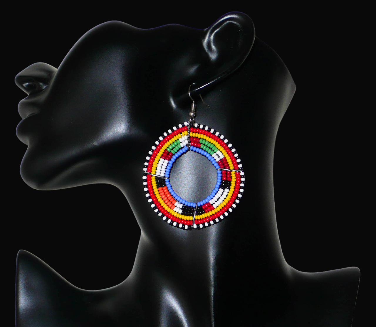 Boucles d'oreilles africaines rondes traditionnelles à motifs ethniques Massai composées de perles de rocaille bleues et multicolores glissées sur des structures circulaires en fils de fer.

Ces créoles perlées aux accents afro chic des années 70 mesurent 7 cm de long et 5 cm de large ; elles se portent avec des crochets en acier inoxydable sur des oreilles percées.