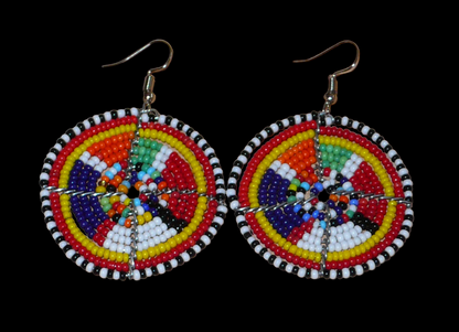 Boucles d'oreilles africaines rondes à motifs ethniques Massai en perles de rocaille multicolores. Elles mesurent 6 cm de long et 4,5 cm de large, et se portent avec des crochets en acier inoxydable sur des oreilles percées.