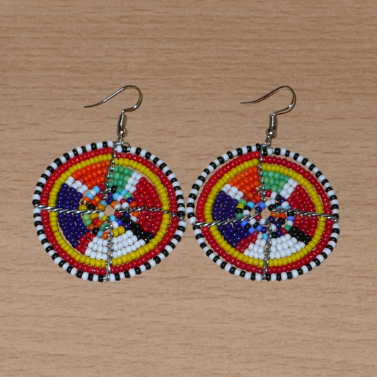 Boucles d'oreilles africaines rondes à motifs ethniques Massai en perles de rocaille multicolores. Elles mesurent 6 cm de long et 4,5 cm de large, et se portent avec des crochets en acier inoxydable sur des oreilles percées.