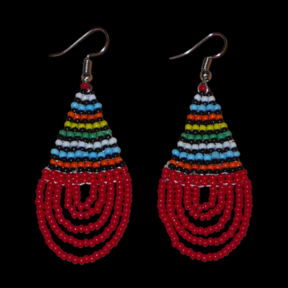 Boucles d'oreilles africaines rouges et multicolores en forme de gouttes. Elles mesurent 7 cm de long et 2,5 cm de large, et se portent sur des oreilles percées.