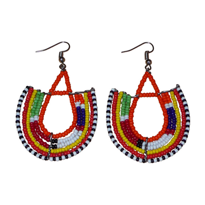 Boucles d'oreilles africaines traditionnelles aux couleurs et motifs ethniques Massai caractéristiques de l'artisanat kenyan. Elles se composent de perles de rocaille orange et multicolores fixées sur des structures en fils de fer en forme d'ancres. Ces boucles d'oreilles tribales mesurent 7.5 cm de long et 4.5 cm de large ; elles se portent avec des crochets en acier inoxydable sur des oreilles percées.